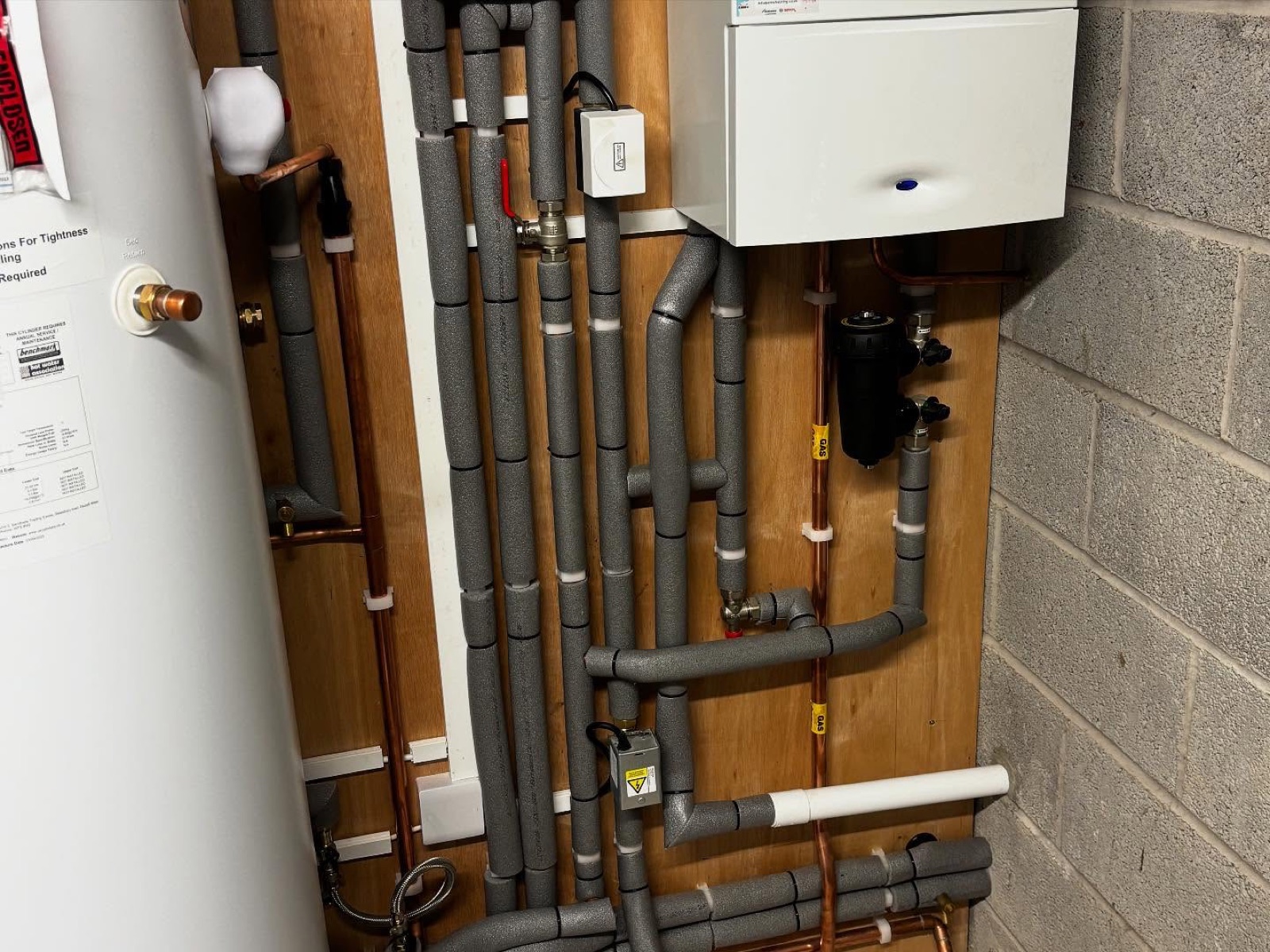 Boiler and insulated heating pipework in a plant room