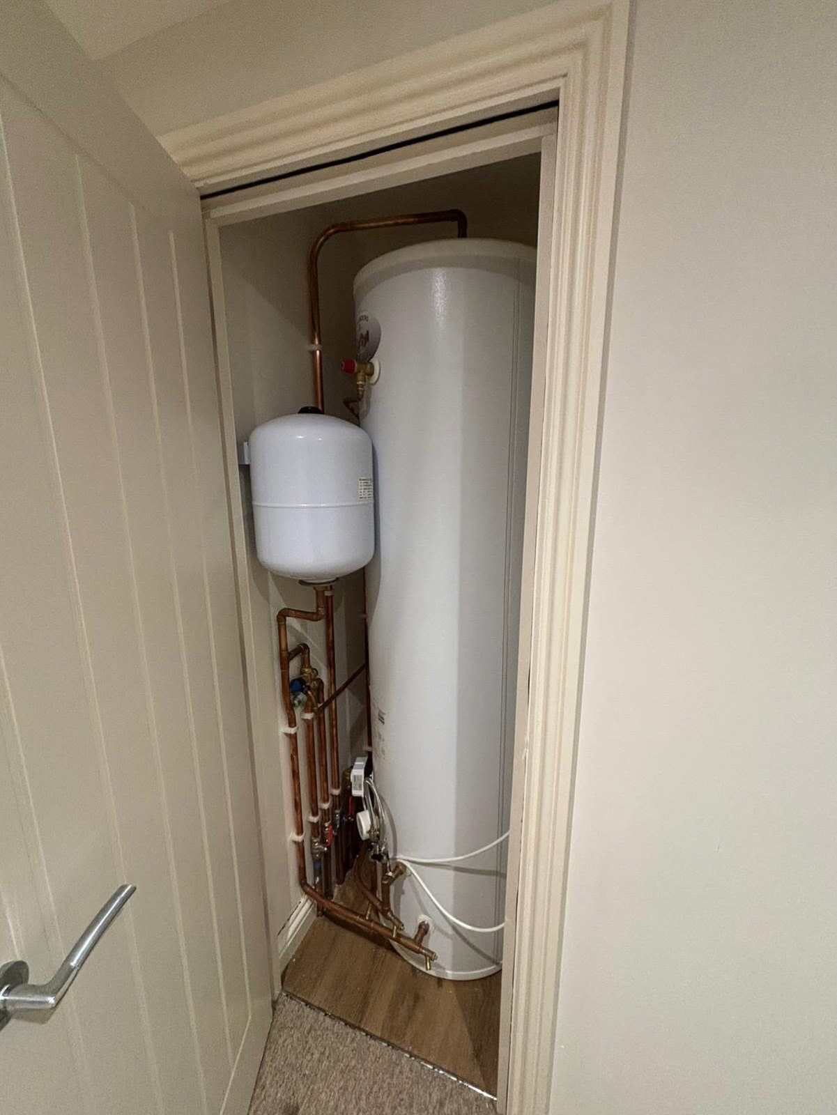 Unvented hot water cylinder fitted in an airing cupboard